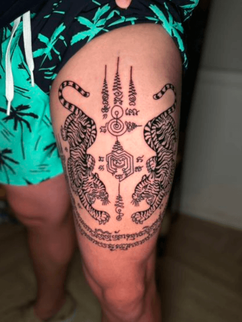 Thai Sak Yant twin-tiger tattoo on the thigh